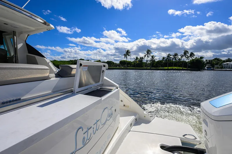 Let It Out Yacht Photos Pics 2022 Tiara Yachts 43 LE on water, sunny day, palm trees in background.