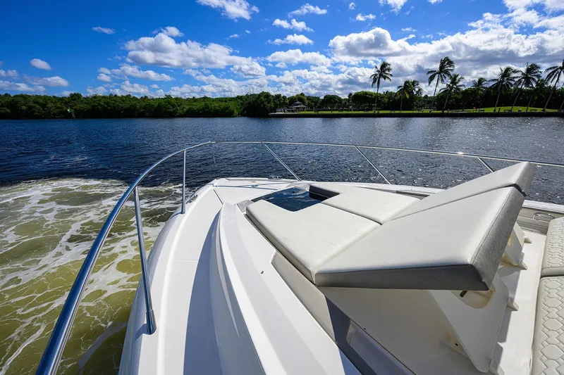 Let It Out Yacht Photos Pics 2022 Tiara Yachts 43 LE cruising on a sunny day with palm trees in the background.