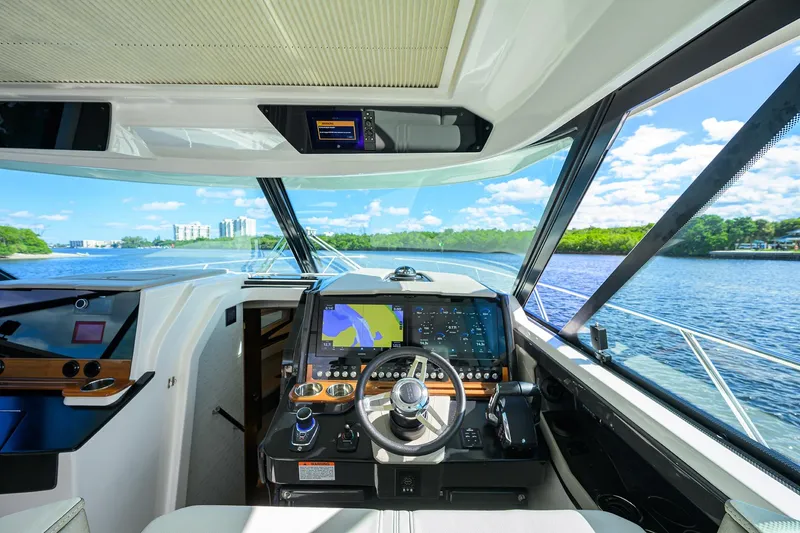 Let It Out Yacht Photos Pics 2022 Tiara Yachts 43 LE helm with modern navigation system and scenic waterway view.