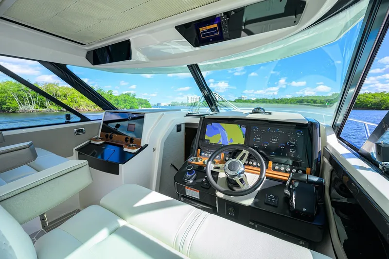 Let It Out Yacht Photos Pics 2022 Tiara Yachts 43 LE helm with advanced navigation systems and scenic water view.