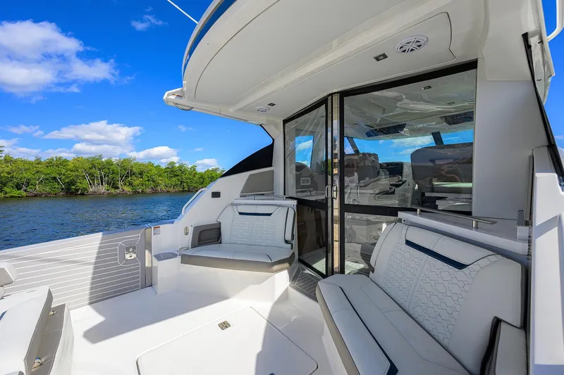 Let It Out Yacht Photos Pics 2022 Tiara Yachts 43 LE luxury yacht interior with seating, river view, and blue sky.