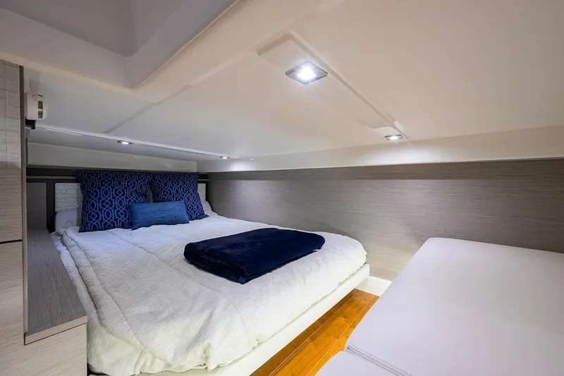 Let It Out Yacht Photos Pics Luxurious cabin interior of 2022 Tiara Yachts 43 LE with cozy bedding and modern lighting.