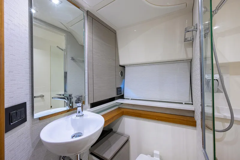Let It Out Yacht Photos Pics Modern bathroom interior of 2022 Tiara Yachts 43 LE, featuring sleek sink and mirror.