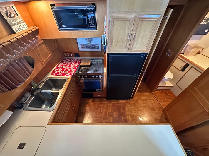  Yacht Photos Pics 1987 Ocean Alexander 46 Cockpit Motor Yacht kitchen with wood cabinetry and modern appliances.