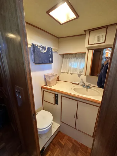  Yacht Photos Pics 1987 Ocean Alexander 46 Cockpit Motor Yacht bathroom with sink, toilet, and wooden cabinetry.