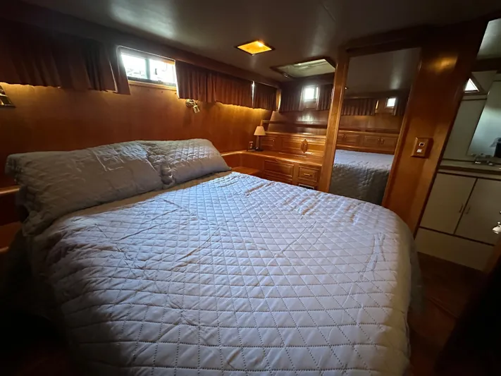  Yacht Photos Pics Cozy bedroom in 1987 Ocean Alexander 46 Cockpit Motor Yacht with wood paneling and quilted bedding.