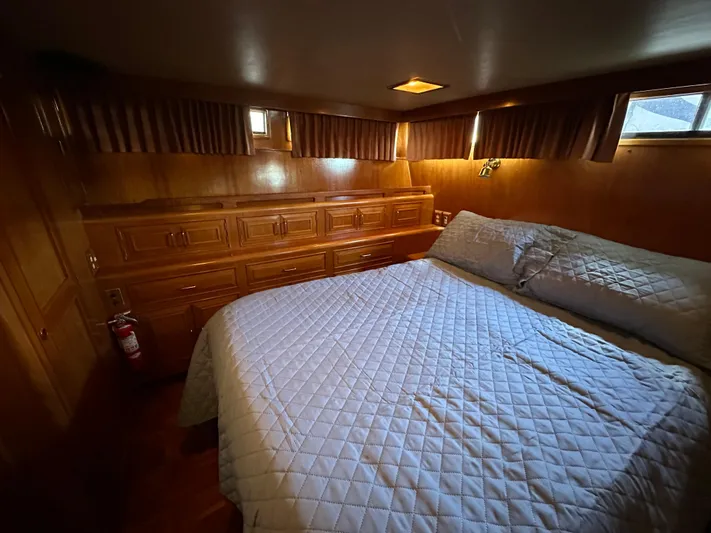  Yacht Photos Pics Cozy bedroom in 1987 Ocean Alexander 46 Cockpit Motor Yacht with wood paneling and quilted bedding.