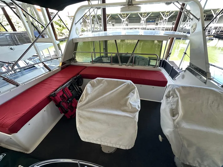  Yacht Photos Pics 1987 Ocean Alexander 46 Cockpit Motor Yacht interior with red seating and covered chairs.
