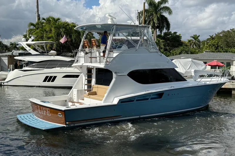One Life Yacht Photos Pics Hatteras 50 Convertible yacht, 2000 model, cruising on a sunny day near a marina.