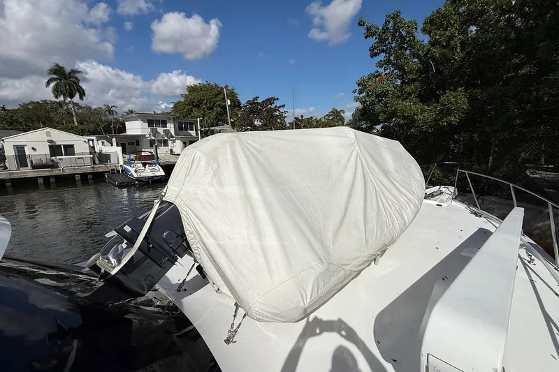 One Life Yacht Photos Pics Covered equipment on 2000 Hatteras 50 Convertible yacht deck, docked near waterfront homes.