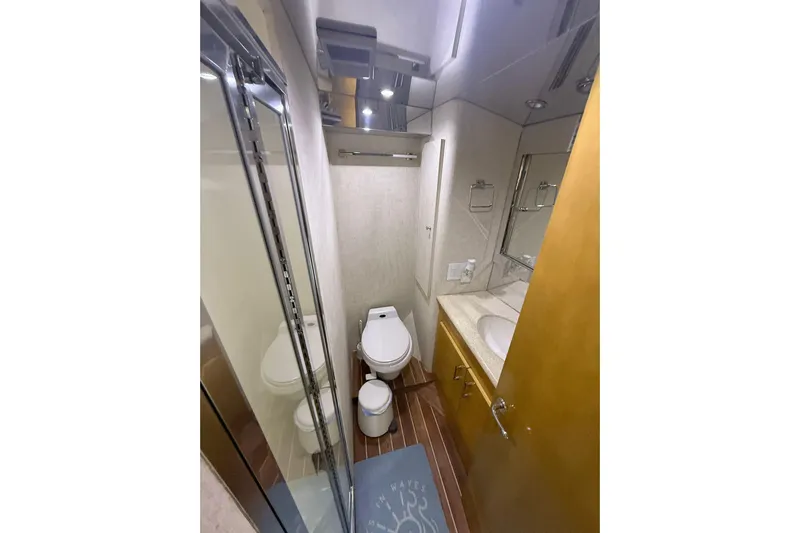 One Life Yacht Photos Pics Bathroom interior of 2000 Hatteras 50 Convertible yacht, featuring toilet, sink, and shower.