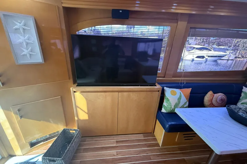 One Life Yacht Photos Pics Interior of 2000 Hatteras 50 Convertible yacht with TV, seating, and decor.