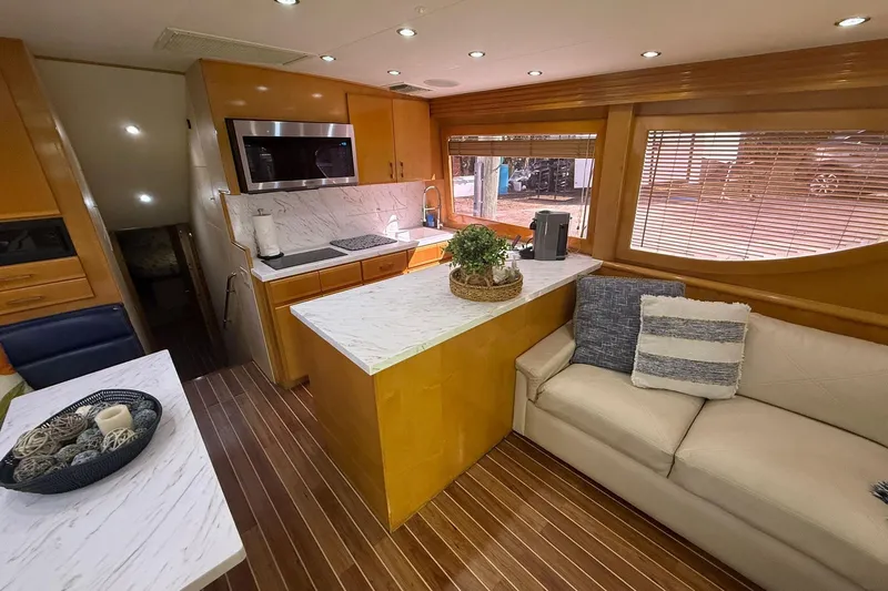 One Life Yacht Photos Pics Luxurious interior of 2000 Hatteras 50 Convertible yacht with modern kitchen and cozy seating.