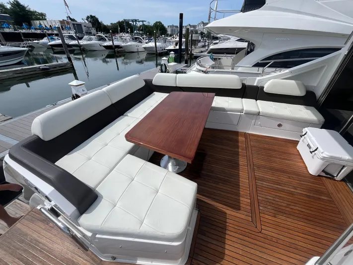 Penny Lane Yacht Photos Pics Luxury seating area on 2014 Azimut 55S yacht, featuring elegant wood table and marina view.