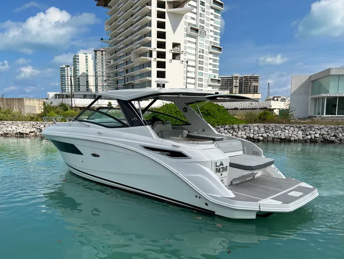 2023 Sea Ray 320 Sundancer @ Canucn Yacht Photos Pics 2023 Sea Ray Sundancer 320 yacht docked in a marina with modern buildings in the background.