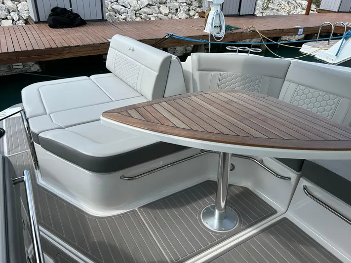 2023 Sea Ray 320 Sundancer @ Canucn Yacht Photos Pics 2023 Sea Ray Sundancer 320 boat interior with cushioned seating and wooden table.