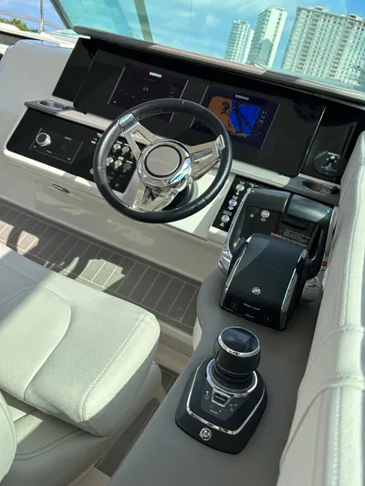 2023 Sea Ray 320 Sundancer @ Canucn Yacht Photos Pics 2023 Sea Ray Sundancer 320 helm with modern controls and cityscape view.