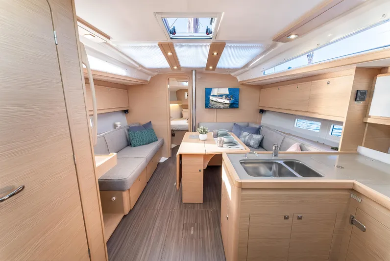 In Stock #325 Yacht Photos Pics Modern interior of 2023 Dufour 390 yacht with sleek kitchen and cozy seating area.