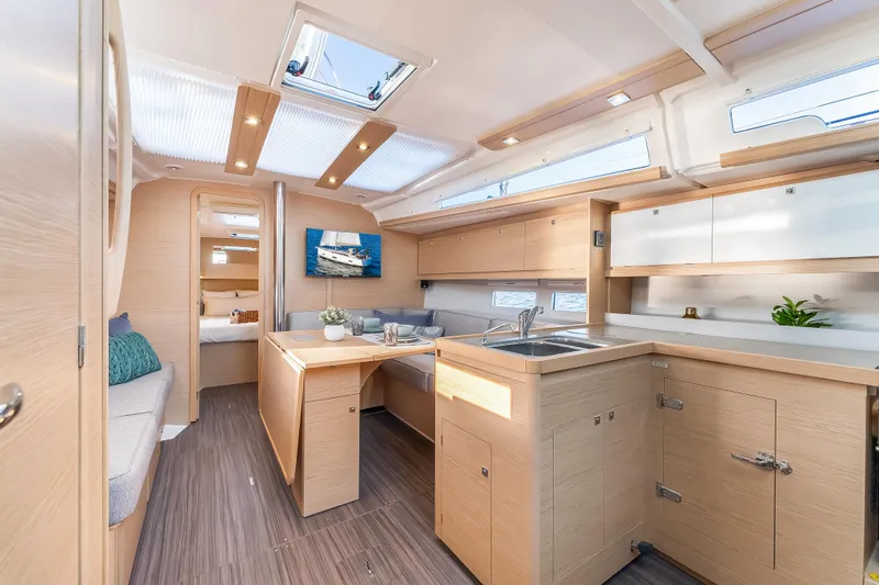 In Stock #325 Yacht Photos Pics Modern interior of 2023 Dufour 390 yacht with sleek kitchen and dining area.