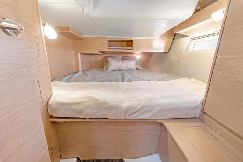 In Stock #325 Yacht Photos Pics Cozy cabin interior of 2023 Dufour 390 yacht with wooden finish and comfortable bedding.