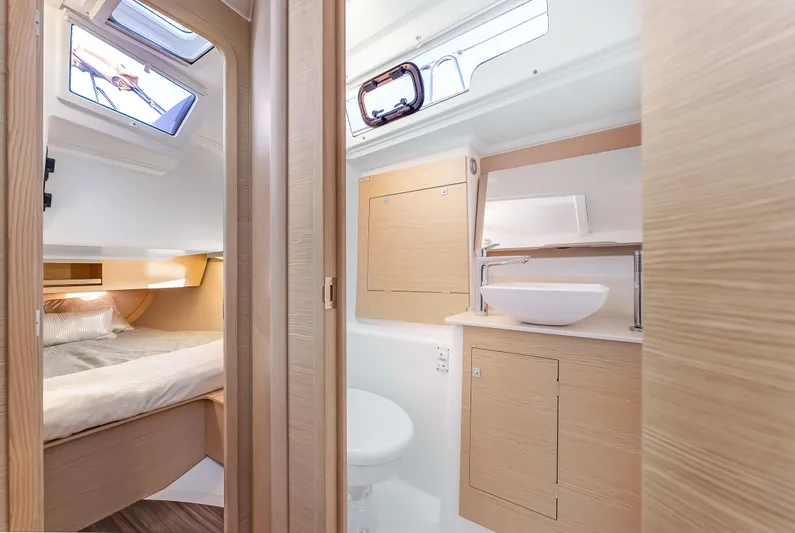 In Stock #325 Yacht Photos Pics Modern interior of 2023 Dufour 390 yacht, featuring a cozy bedroom and sleek bathroom.