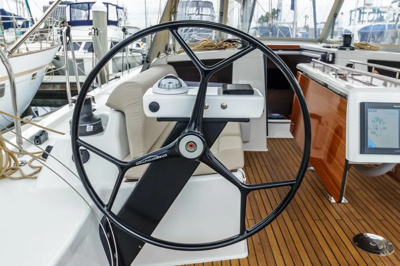 In Stock #325 Yacht Photos Pics 2023 Dufour 390 yacht steering wheel and cockpit with teak flooring.