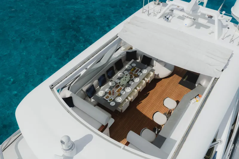 Carpe Diem Yacht Photos Pics Luxurious 2023 Azimut yacht with elegant dining setup on deck, surrounded by clear blue water.