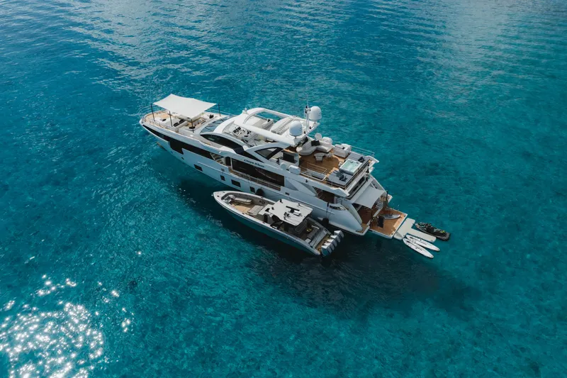 Carpe Diem Yacht Photos Pics Luxurious 2023 Azimut yacht on clear blue water, featuring spacious deck and watercraft accessories.
