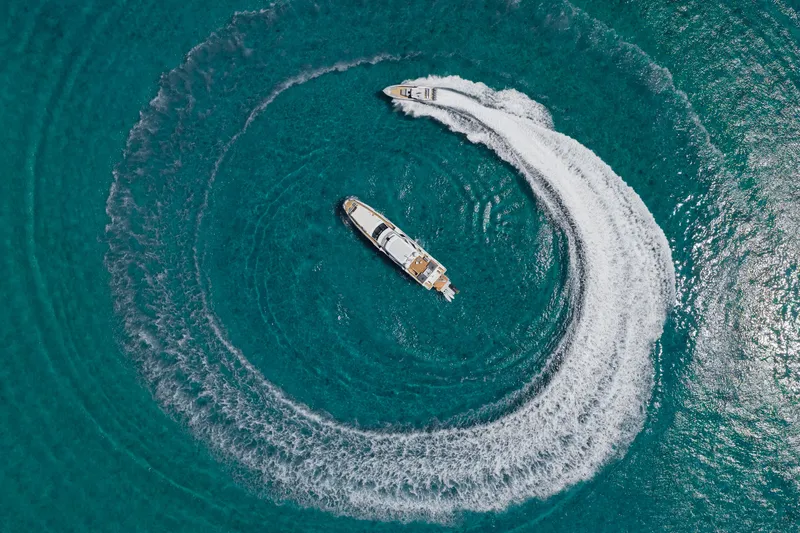 Carpe Diem Yacht Photos Pics Aerial view of 2023 Azimut yacht creating circular wake in turquoise water.