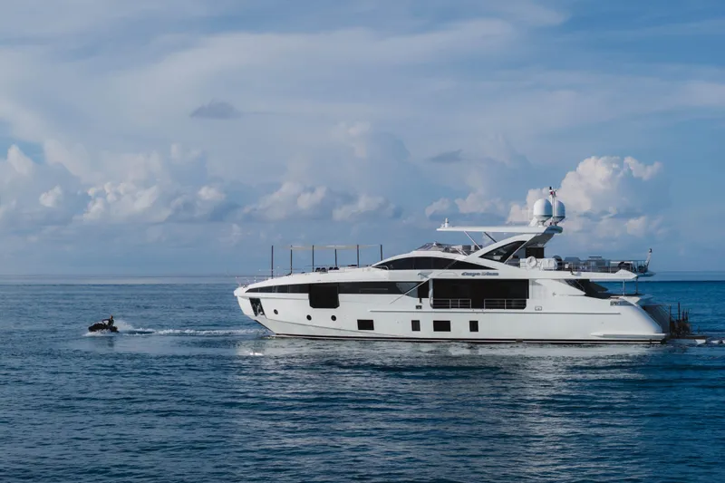 Carpe Diem Yacht Photos Pics Luxury Azimut yacht cruising on the ocean, 2023 model, with a jet ski nearby.