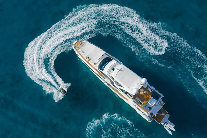Carpe Diem Yacht Photos Pics Aerial view of 2023 Azimut yacht with jet ski creating waves in blue ocean.