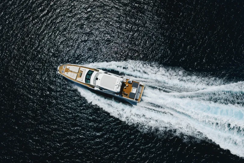 Carpe Diem Yacht Photos Pics Aerial view of 2023 Azimut yacht cruising on open water, leaving a white wake.
