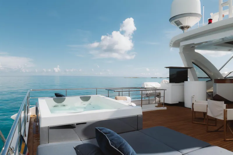 Carpe Diem Yacht Photos Pics Luxurious 2023 Azimut yacht deck with jacuzzi, ocean view, and clear blue sky.
