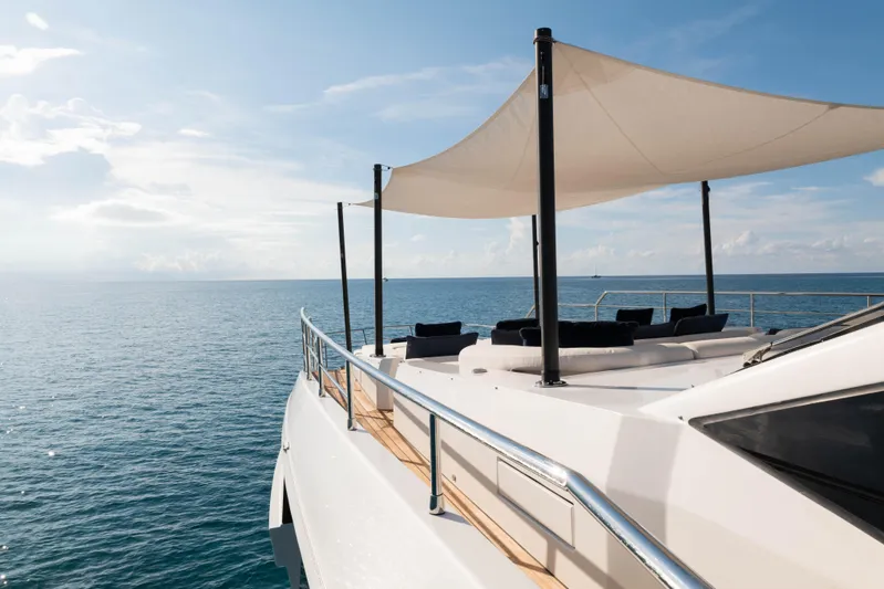 Carpe Diem Yacht Photos Pics Luxurious 2023 Azimut yacht deck with sunshade, overlooking serene ocean waters.