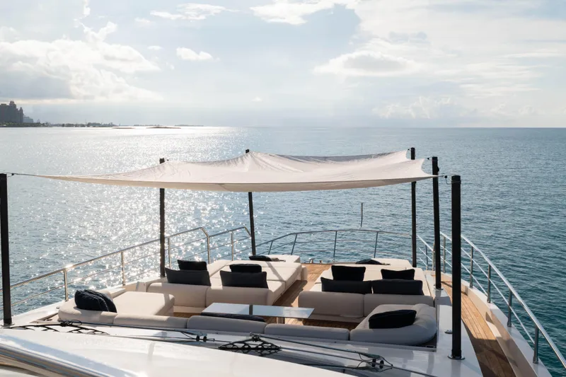 Carpe Diem Yacht Photos Pics Luxurious 2023 Azimut yacht deck with shaded seating, overlooking serene ocean waters.