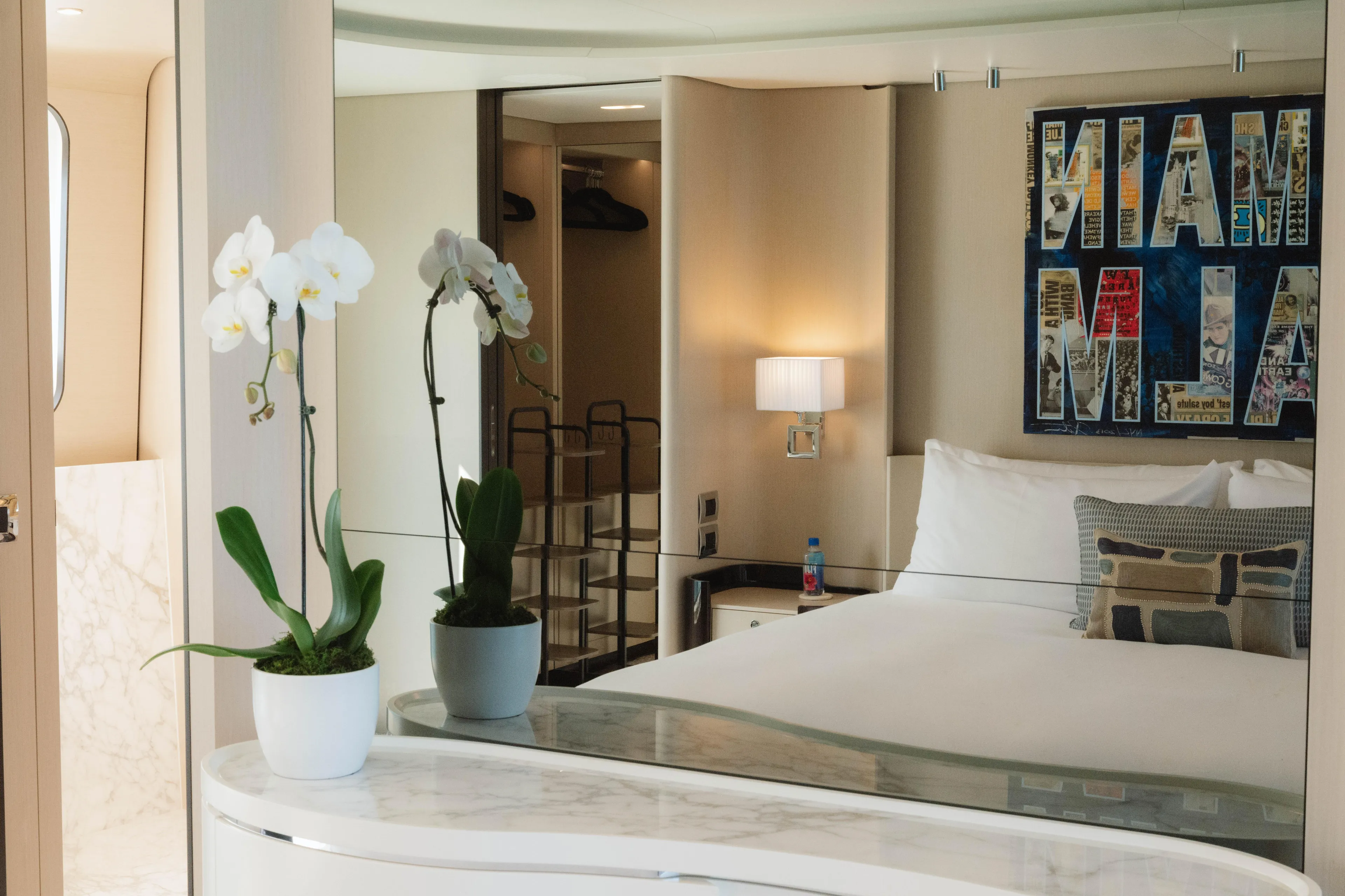 Carpe Diem Yacht Photos Pics Luxurious Azimut yacht bedroom with elegant decor, orchids, and Miami-themed artwork, 2023 model.