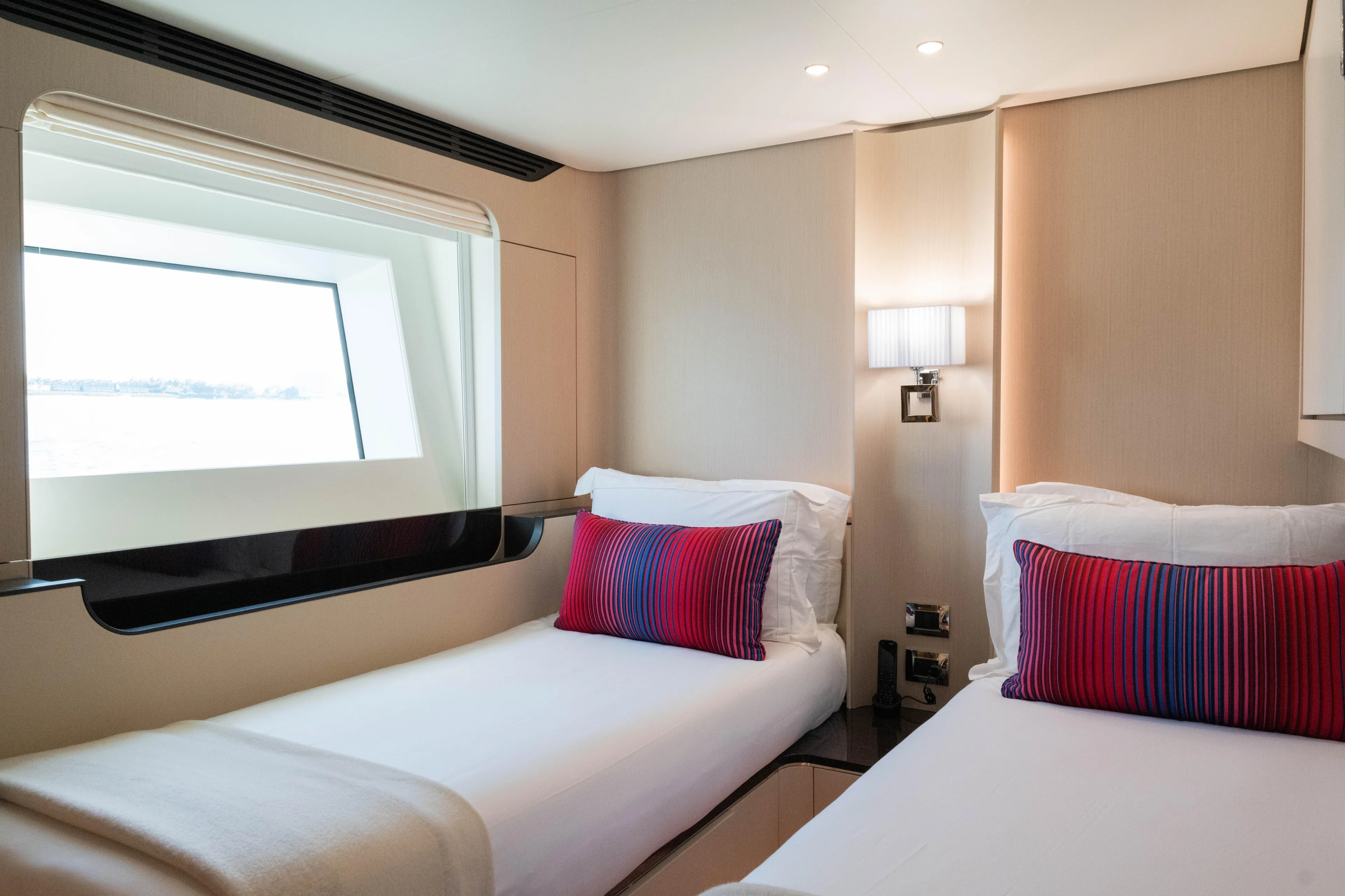 Carpe Diem Yacht Photos Pics Luxurious 2023 Azimut yacht cabin with twin beds, modern decor, and ocean view window.