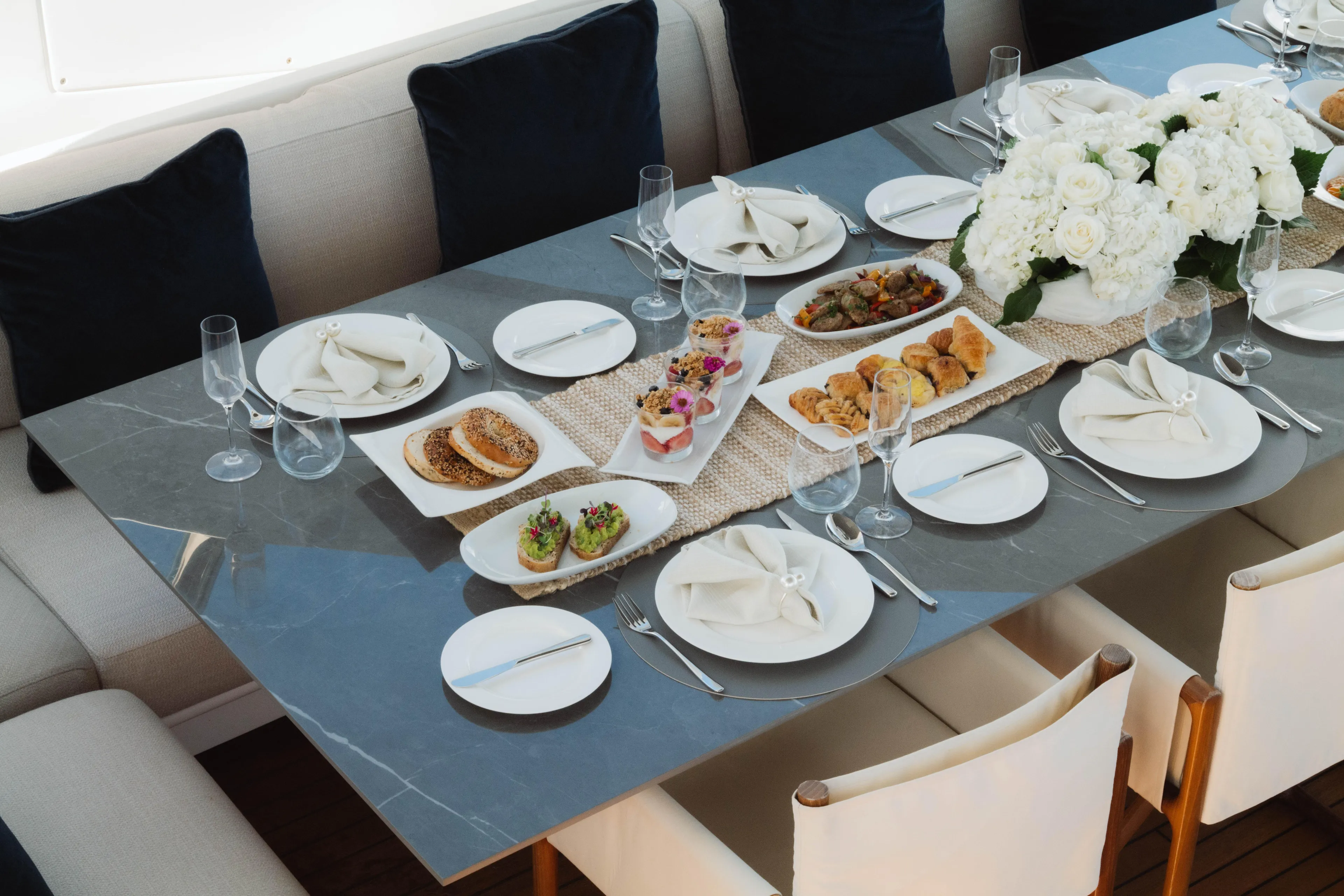 Carpe Diem Yacht Photos Pics Elegant dining setup on Azimut yacht, featuring gourmet appetizers and floral centerpiece, 2023.