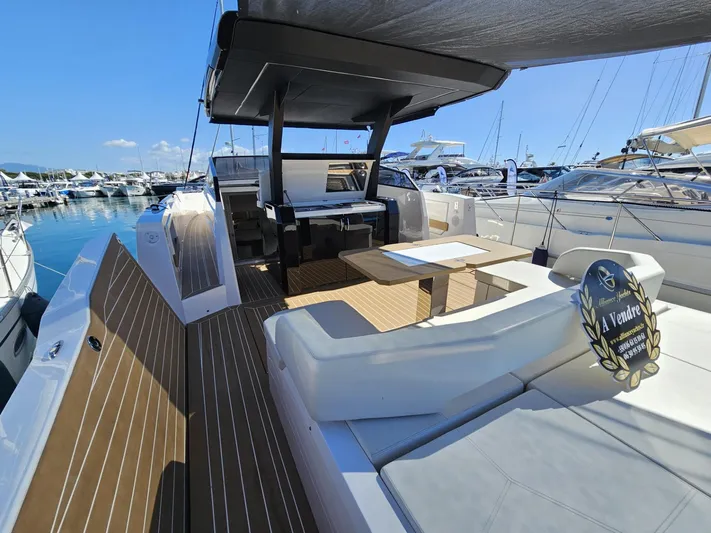 Rio 50 Yacht Photos Pics 2024 Rio Yachts Daytona 50 luxury yacht deck with seating and table, docked at marina.