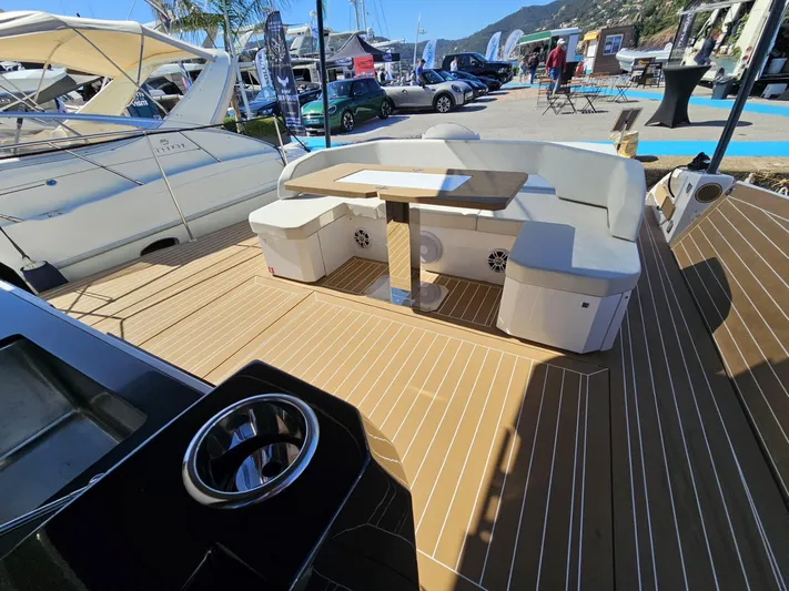 Rio 50 Yacht Photos Pics 2024 Rio Yachts Daytona 50 deck with seating and table, docked at marina.