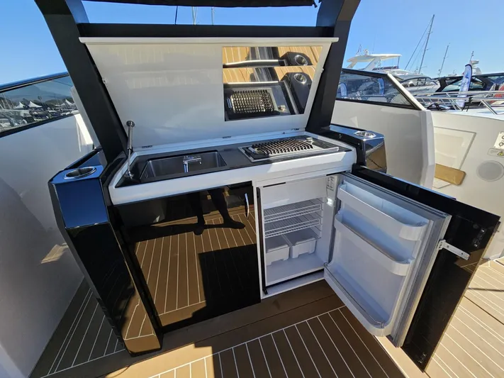 Rio 50 Yacht Photos Pics Outdoor kitchenette on 2024 Rio Yachts Daytona 50, featuring sink, grill, and open fridge.