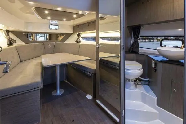 My Angel Yacht Photos Pics 2023 Beneteau GT32 interior with dining area and compact bathroom, featuring modern design and lighting.