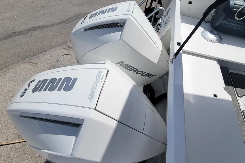 Tagwood Bbq Yacht Photos Pics Twin Mercury outboard engines on a 2023 Jeanneau NC 895 boat, docked on concrete.