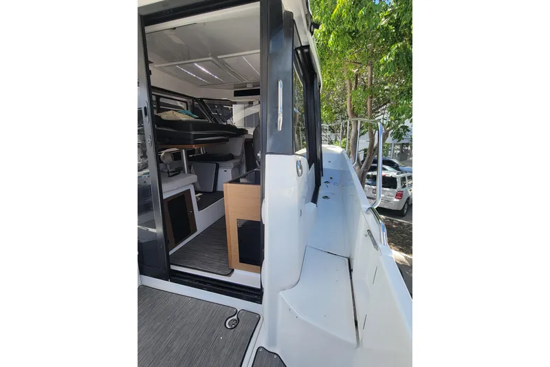 Tagwood Bbq Yacht Photos Pics 2023 Jeanneau NC 895 boat interior with open door, showcasing modern design and seating.