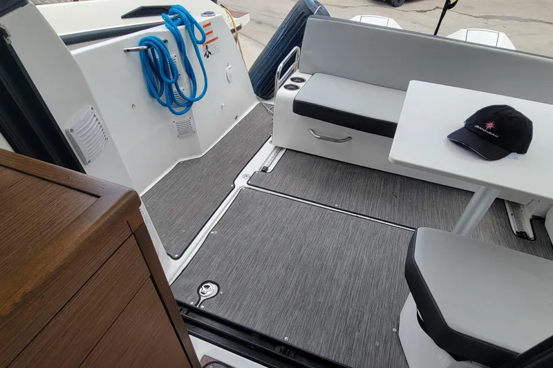 Tagwood Bbq Yacht Photos Pics 2023 Jeanneau NC 895 boat interior with seating, table, and coiled blue rope.