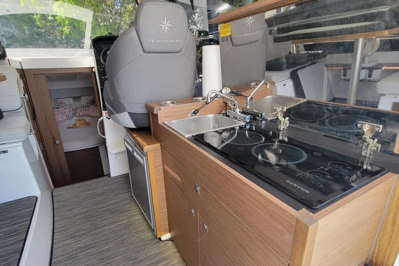 Tagwood Bbq Yacht Photos Pics 2023 Jeanneau NC 895 interior with kitchenette and cozy cabin view.