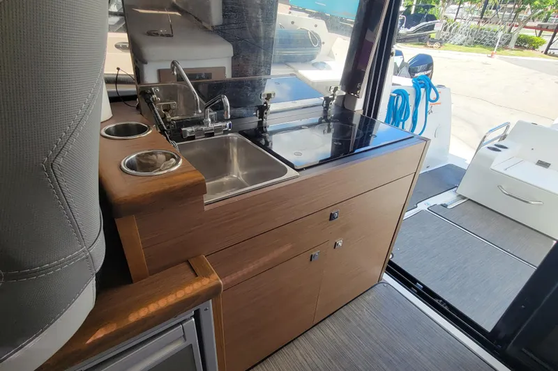 Tagwood Bbq Yacht Photos Pics 2023 Jeanneau NC 895 boat interior with compact kitchen and sink area.