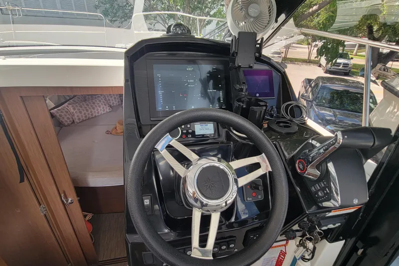 Tagwood Bbq Yacht Photos Pics 2023 Jeanneau NC 895 helm with modern navigation controls and cozy cabin view.