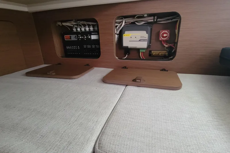 Tagwood Bbq Yacht Photos Pics 2023 Jeanneau NC 895 interior electrical panel with wooden covers and wiring.