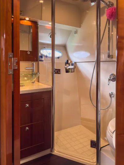  Yacht Photos Pics Luxurious bathroom in 2012 Riviera 50SY yacht with glass shower and wooden cabinetry.